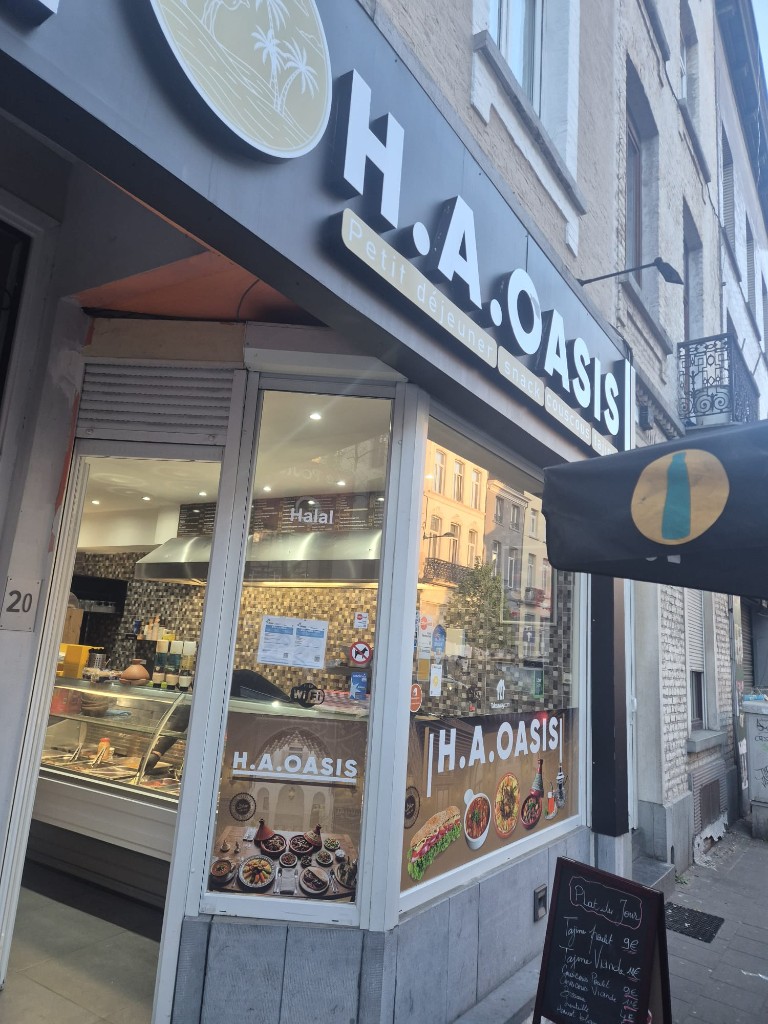 Façade du restaurant H.A. OASIS à Schaerbeek, enseigne noire et dorée